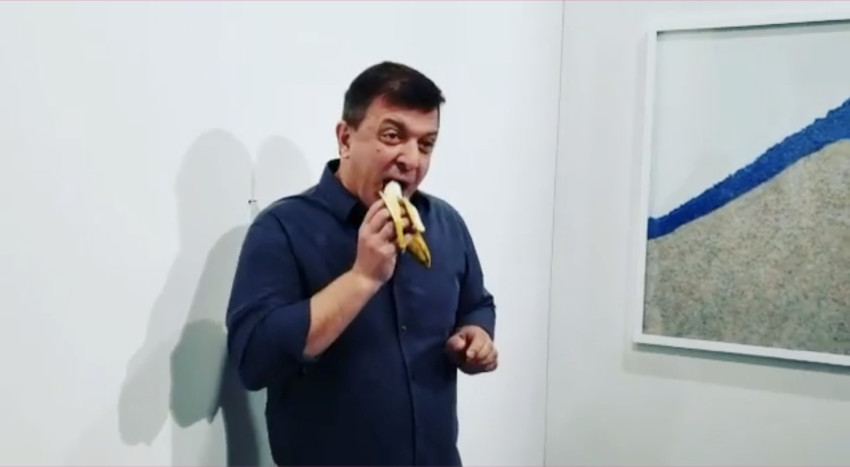 David Datuna eating the banana at Galerie Perrotin booth at Art Basel 2019